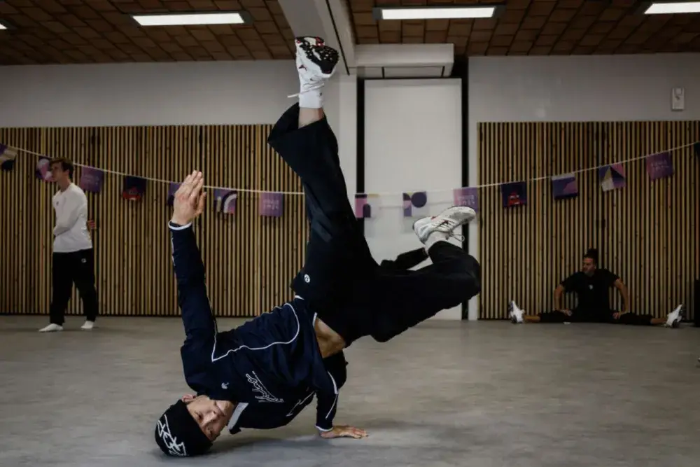 Breaking at Paris 2024 Olympics: Breakdancer in action showcasing dynamic moves during competition